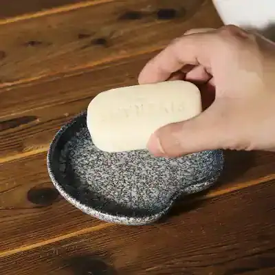 Bar of soap on a black and white textured dish at Monalisa Store, skincare, luxury soap, natural ingredients, wellness products, boutique spa essentials, elegant hygiene accessories, premium toiletries, organic skincare, beauty and health products.