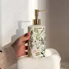 Hand holding a floral-patterned soap dispenser at Monalisa Store, perfect for aesthetic bathroom decor and skincare routines.