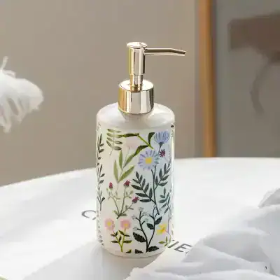 Lotion dispenser with floral pattern and gold pump, perfect for bathroom decor and skincare routines.