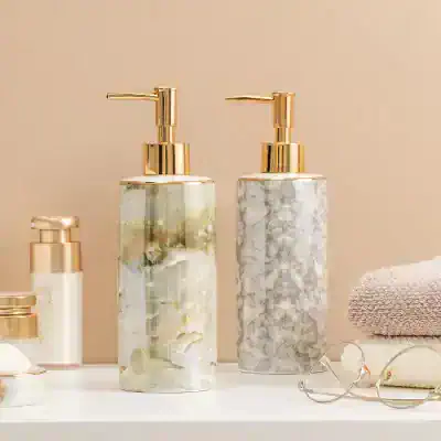 Luxury marble-patterned soap dispensers with gold pump tops for bathroom decor at Monalisa Store.