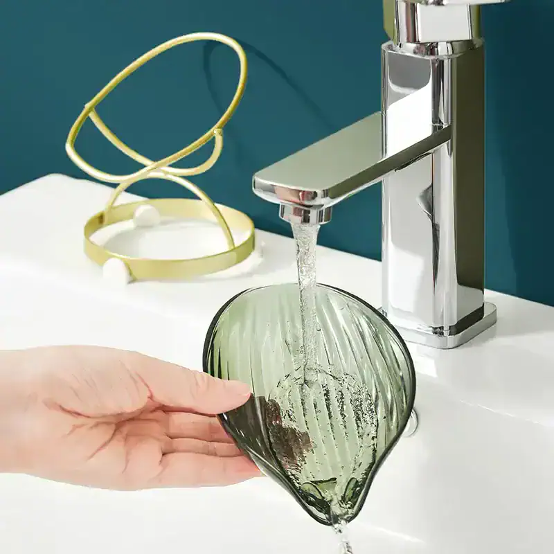 Cleaning eyeglasses under a modern faucet at Monalisa Store for optimal optical care and eyewear maintenance.