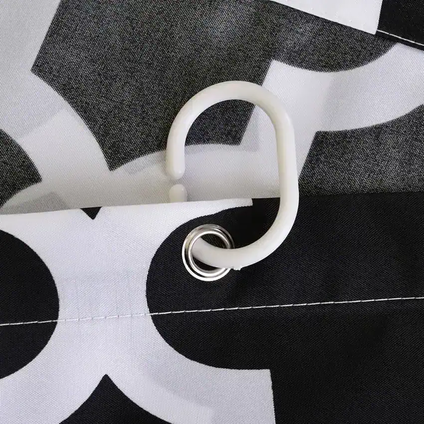 Flexible white plastic handle attached to a black and white patterned fabric tote bag, designed for secure grip and convenience, ideal for carrying medical or optical supplies.