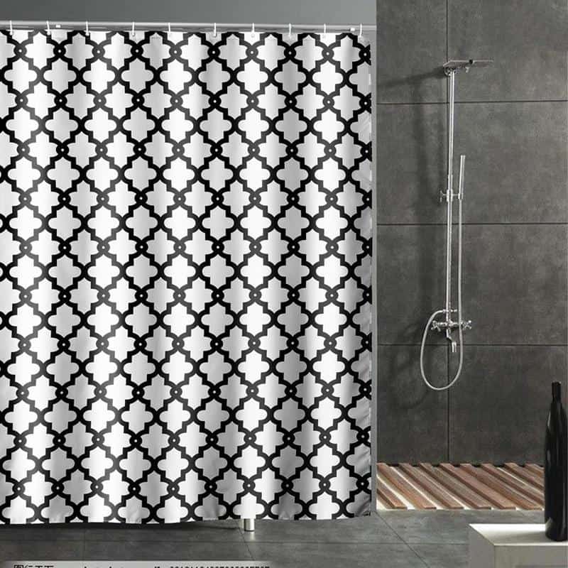 Vibrant black and white geometric shower curtain in modern bathroom with rain shower head and gray tiled walls.