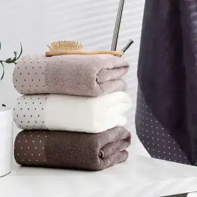 Luxury towels stacked with a wooden bath brush and grooming tools, elegant bathroom accessories, soft and plush texture, Monalisa Store home spa essentials, modern and stylish bathroom decor, high-quality textile products, wellness and self-care items for a comfortable home environment.