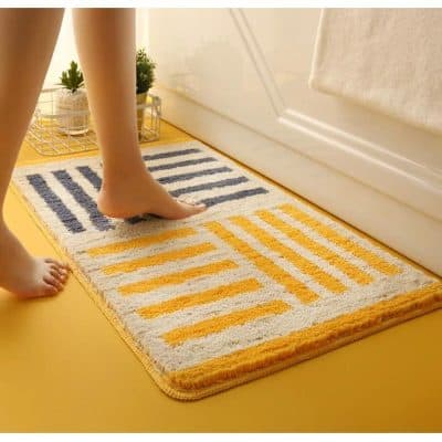 Modern geometric bathroom rug with yellow and navy blue stripes, soft plush texture, perfect for enhancing bathroom decor and providing comfort underfoot.