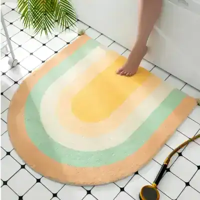 Colorful rainbow bath rug on white tiled floor, soft plush design for bathroom decor and comfort, featuring pastel shades of peach, mint, yellow, and cream. Perfect for enhancing bathroom aesthetics and adding cozy touch.