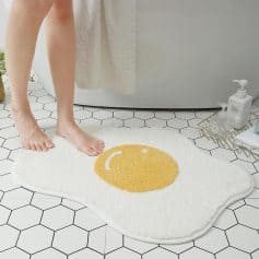 Smiley face bathroom rug on hex tile floor, cozy and decorative bath mat for home or spa, perfect for adding fun to your bathroom decor.