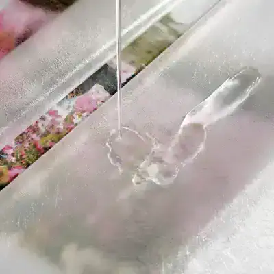 Delicate acrylic nail tip with glue application process at Monalisa Store for professional nail enhancement.