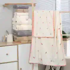 Soft plush towels and cozy embroidered blanket with pink accents displayed in modern bathroom setting for home comfort and luxury.