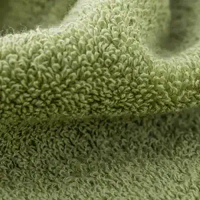 Soft plush green towel with textured, curly fibers for skincare and face cleansing at Monalisa Medical Store. Ideal for spa, beauty treatments, and personal care routines.