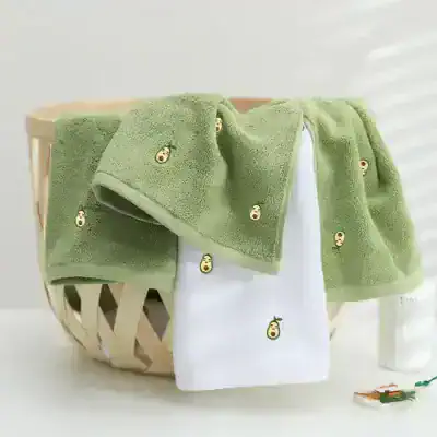 Soft green towels with embroidered avocado face design, perfect for a stylish home or bathroom decor, featuring high-quality absorbent fabric for daily use.