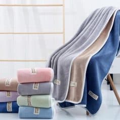 Soft plush towels in pastel colors, displayed on a clean modern bathroom setting, emphasizing luxurious and high-quality bathroom essentials. Perfect for home spa, hotel, and retail stores specializing in premium towels.