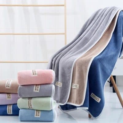 Soft plush towels in pastel colors, displayed on a clean modern bathroom setting, emphasizing luxurious and high-quality bathroom essentials. Perfect for home spa, hotel, and retail stores specializing in premium towels.
