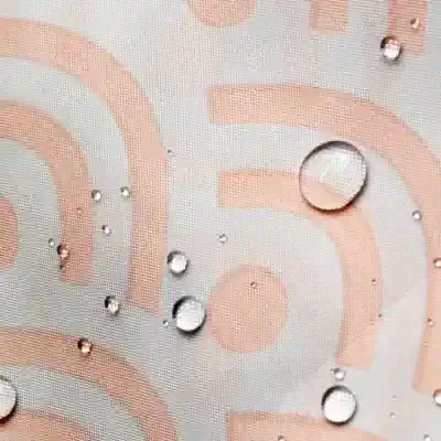 Shiny water droplets on a textured surface with a geometric pattern, emphasizing durability and water resistance for optical products.