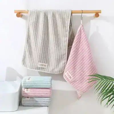 Soft striped cotton bath towels in pastel colors, ideal for spa and skincare routines, displayed in a minimalistic setting for a luxurious feel.
