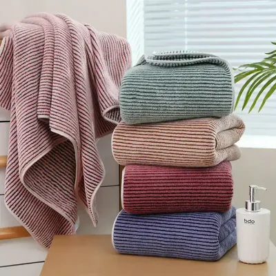 Soft, striped towels and blankets displayed in a cozy home setting at Monalisa Store, perfect for bath or bedroom decor, emphasizing comfort and quality textiles for premium home essentials.