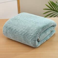 Extra soft microfiber cleaning cloth folded on wooden surface for efficient and gentle cleaning.