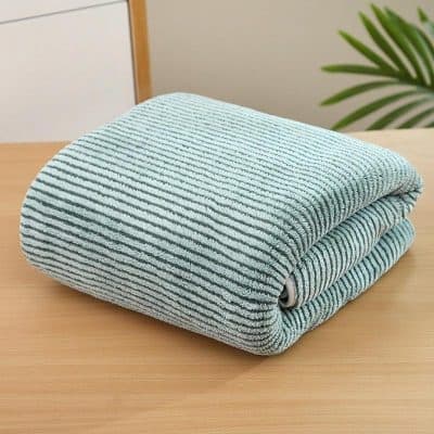 Extra soft microfiber cleaning cloth folded on wooden surface for efficient and gentle cleaning.