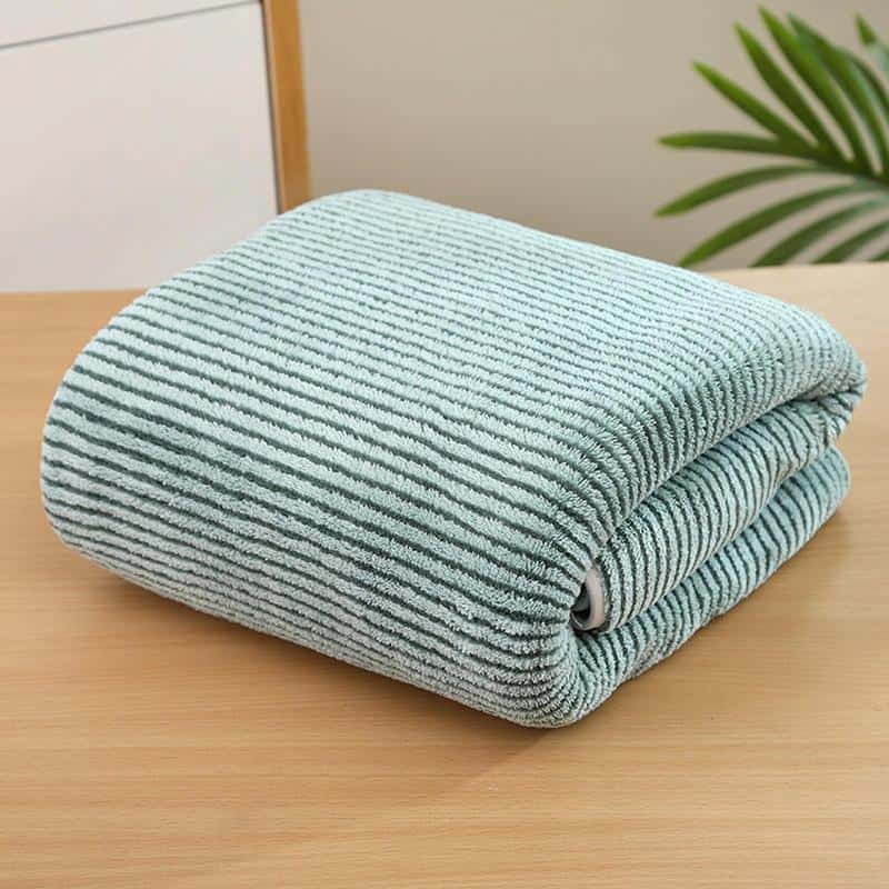 Extra soft microfiber cleaning cloth folded on wooden surface for efficient and gentle cleaning.