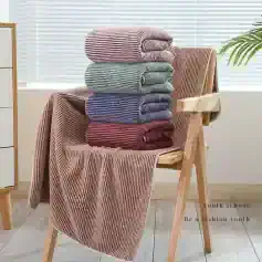Soft striped towels in pastel colors stacked on wooden chair, perfect for cozy home decor and luxury bathroom sets.