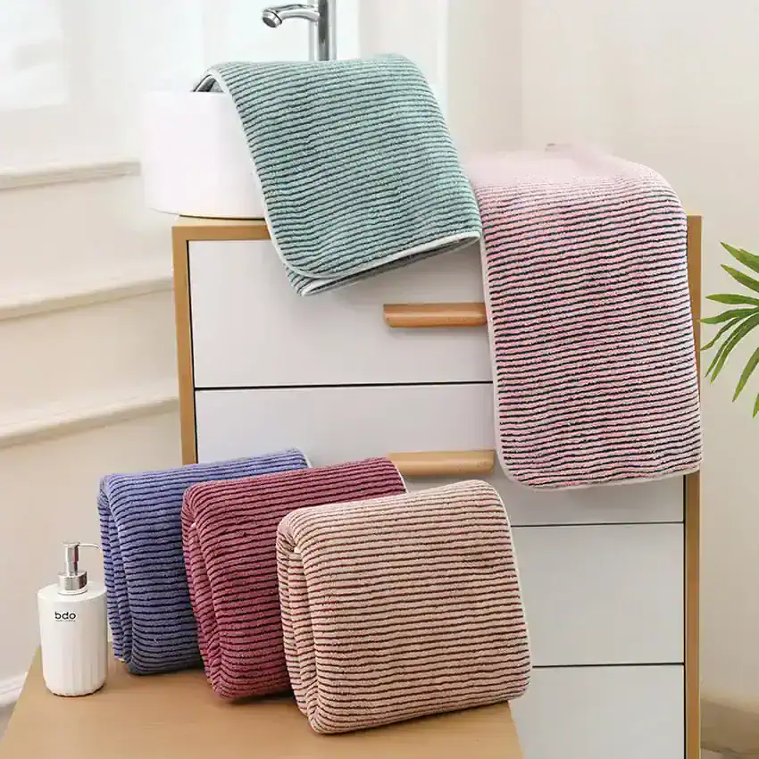 Striped bathroom towels and accessories on a modern storage cabinet, promoting Monalisa Medical's premium bath linens and wellness products for a luxurious home spa experience.