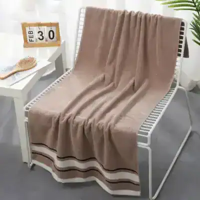 Luxurious beige towel draped over a modern white bench, perfect for spa or bathroom decor, emphasizing comfort and style.