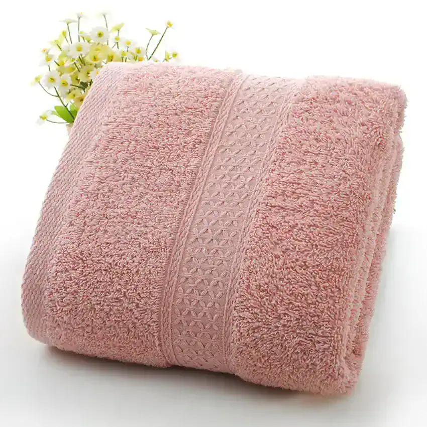 Luxury pink terry cloth bath towel with decorative border for spa and hotel use.