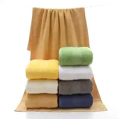 Colorful, plush towels neatly folded on a beige towel rack, showcasing high-quality bath linens perfect for home or hotel use.