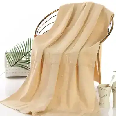 Luxury beige silk blanket displayed on a modern woven chair for home decor and comfort.