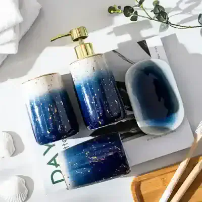 Blue and white marble-themed skincare bottles and soap dish with gold pump, eco-friendly bathroom accessories, Monalisa Medical store premium skincare products, elegant design for beauty and wellness routines, modern bathroom decor relevance.