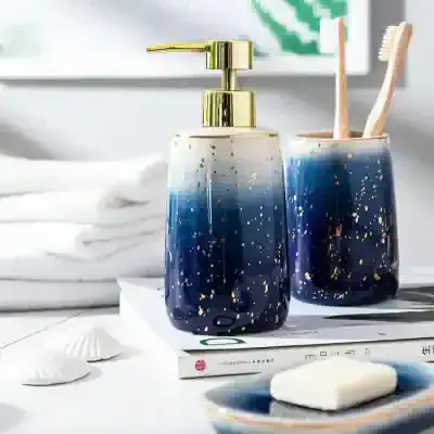 Elegant blue and gold speckled soap dispenser and toothbrush holder from Monalisa Store, perfect for stylish bathroom decor and skincare routines.
