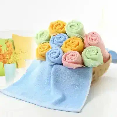 Colorful rolled towels in pastel shades arranged in a basket, perfect for spa or home decor. Soft, plush, and decorative towels ideal for gift sets or bathroom accessories.