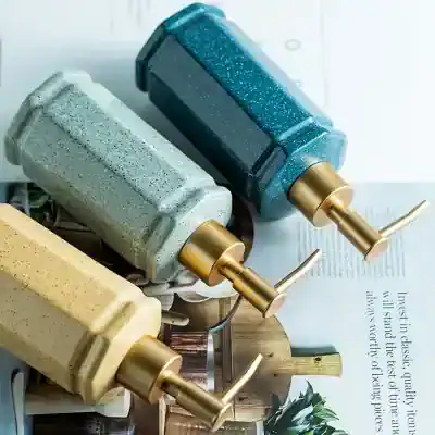 Colorful luxury soap dispensers with gold pumps, perfect for modern bathroom decor.