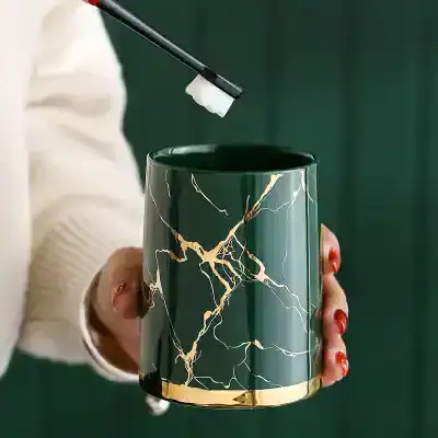 Meticulously crafted reusable coffee mug with black and gold marble design, perfect for stylish coffee lovers on the go.
