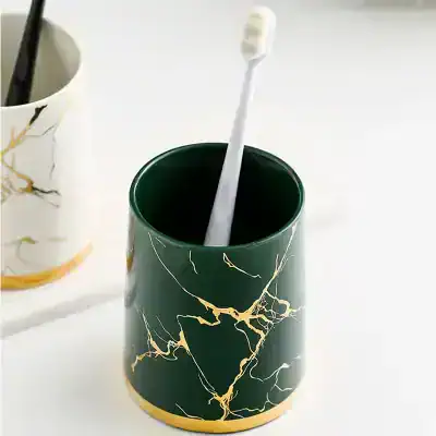 Toothbrush holder with marble design and toothbrush inside, perfect for bathroom storage and organization, complements modern decor, ideal for maintaining oral hygiene.