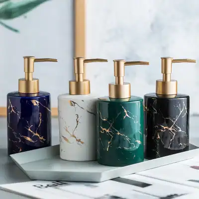 Elegant marble-design liquid soap dispensers with gold pumps, perfect for modern bathroom or kitchen decor - available at Monalisa Store.