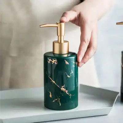 Elegant green marble-textured soap dispenser with gold pump for luxury bathroom decor, perfect for enhancing modern aesthetics.