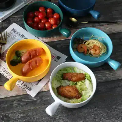 Fresh cherry tomatoes in a green bowl on a rustic wooden table.