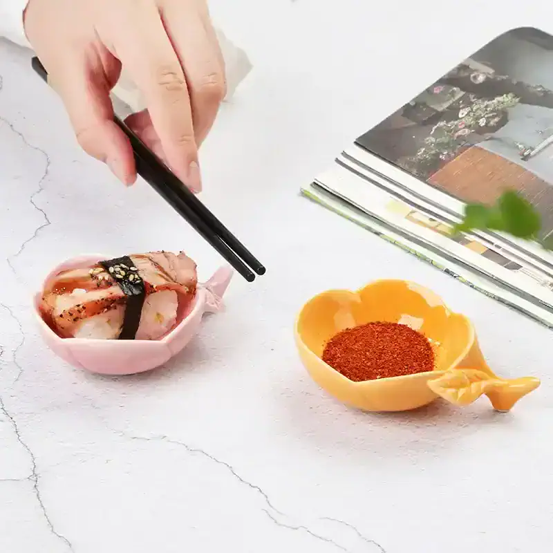 Sushi with chopsticks, spices in a yellow heart-shaped dish, pink ceramic plate with sushi, clean white background, Monalisa Store, sushi and spice essentials for Asian cuisine enthusiasts.