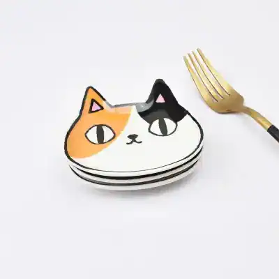 Colorful cat face plates for serving, featuring trendy artistic design with a gold fork included. Perfect for stylish dining and entertaining, adding fun to your table setting.