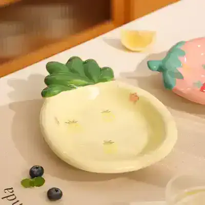 Pineapple-shaped ceramic dish with green leafy top, colorful glaze, and small fruit motifs, ideal for serving or decorative use at Monalisa Medical store.