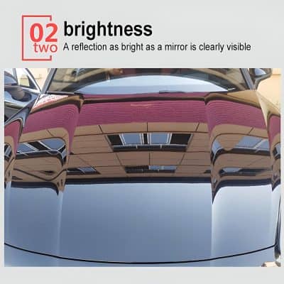 Shiny black car with a highly reflective, mirror-like finish showcasing excellent clarity and brightness, perfect for automotive paint and detailing services.