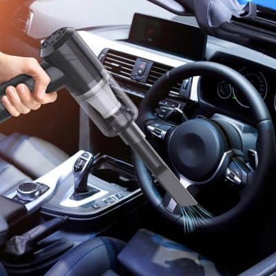 High-powered handheld vacuum cleaner cleaning car interior dashboard, dust removal and detailing, staying hygienic and spotless, ideal for automotive cleaning enthusiasts and professional auto detailers.