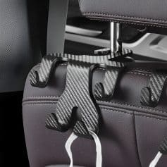 Suction cup hooks attached to a car seat headrest for organizing accessories, featuring a sleek black and carbon fiber design. Perfect for car organization and convenience.