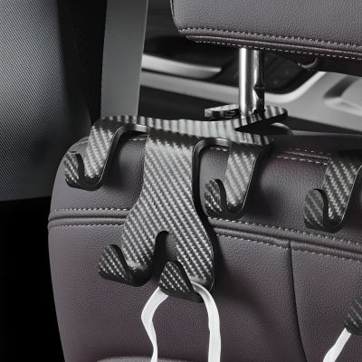 Suction cup hooks attached to a car seat headrest for organizing accessories, featuring a sleek black and carbon fiber design. Perfect for car organization and convenience.