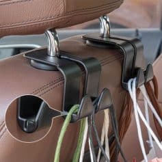 Hanging organizer hooks attached to a car seat headrest, holding shopping bags and accessories for convenient storage and organization.