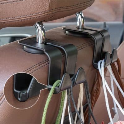Hanging organizer hooks attached to a car seat headrest, holding shopping bags and accessories for convenient storage and organization.