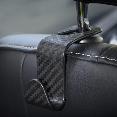 Carbon fiber car phone holder mounted on a car seat headrest for secure travel phone placement.
