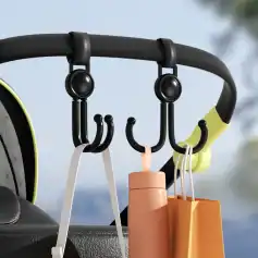 Black and yellow hook rack with shopping bags and water bottle on a car dashboard, outdoor background, organizing everyday essentials while on the go, ideal for travel convenience and car interior accessories.