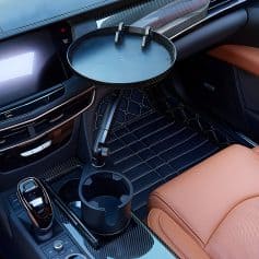 Stunning car interior with a sleek carbon fiber dashboard, tan leather seats, and a stylish cup holder insert, showcasing modern automotive design and luxury features for an exclusive driving experience.